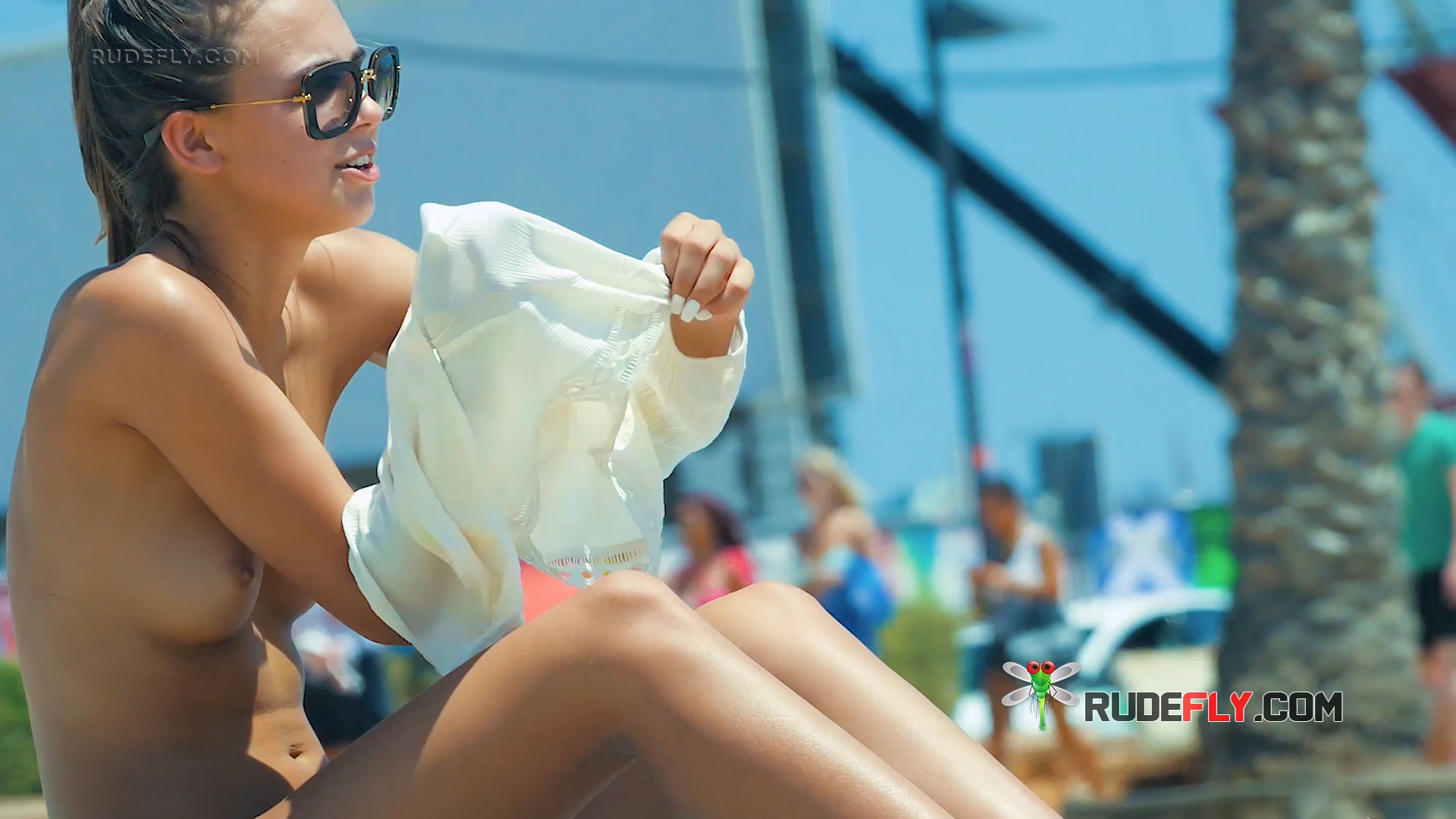 Removing a White Shirt at a Topless Beach in Sunglasses