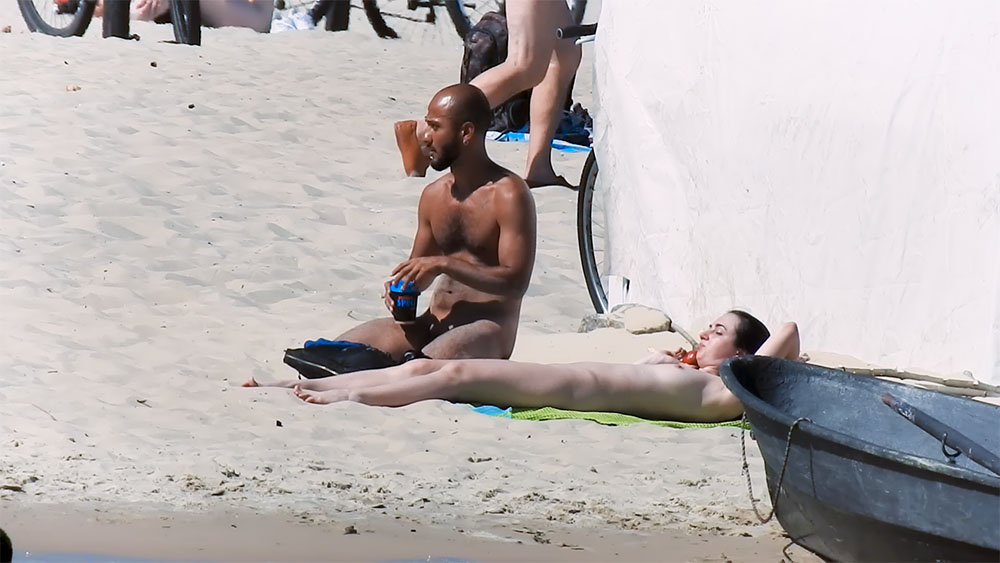 Nude Beach Sunbather Beside a Green Striped Towel