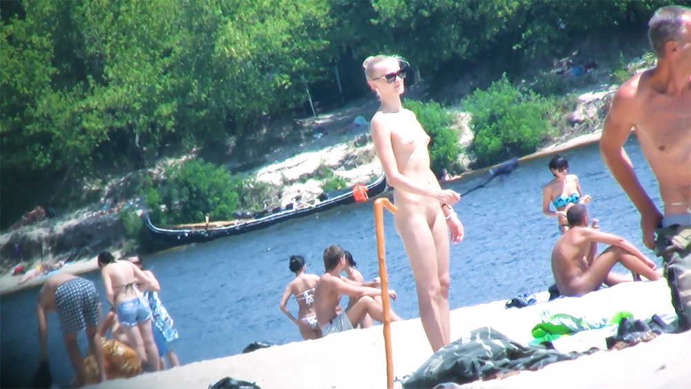 Bij een houten paal aan de oever van een naaktstrand