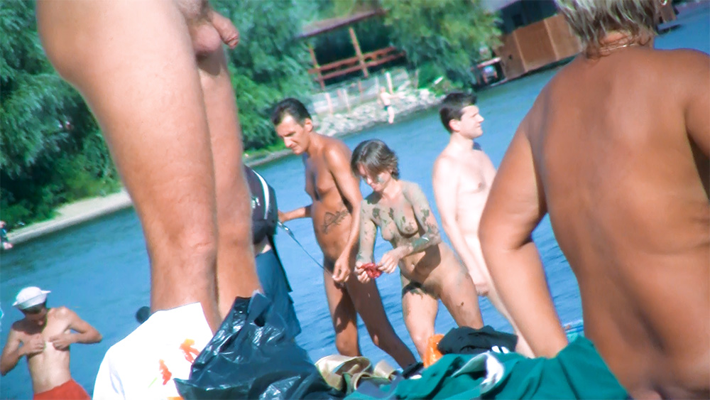 Vier naturisten waden langs de kustlijn