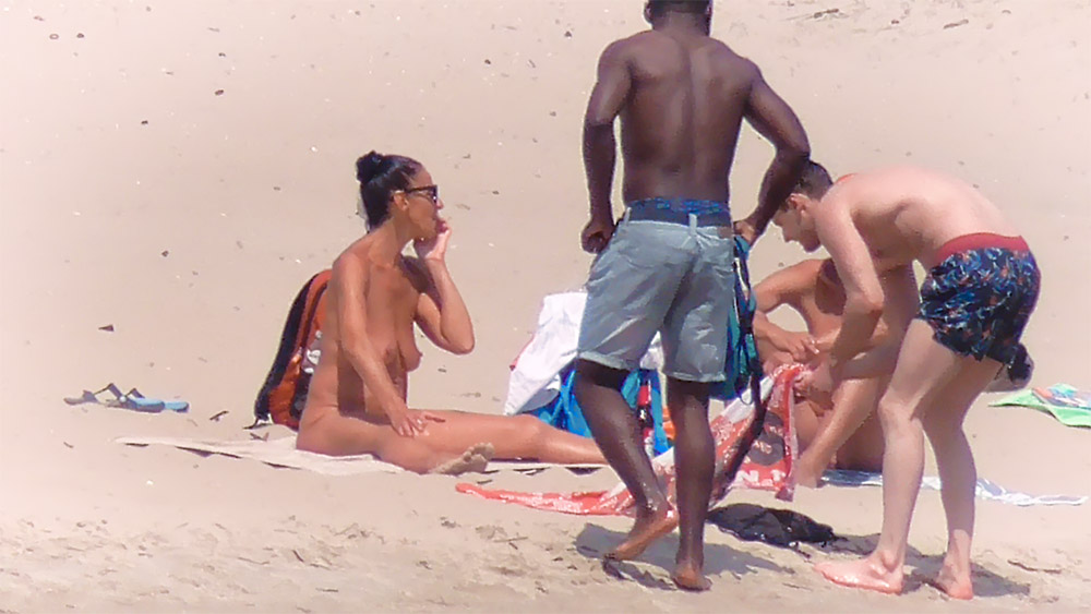 Nude Beach Towel Spot Next to a Bright Orange Backpack