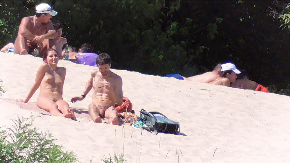 Two Nudists Resting on Bright Sandy Shore