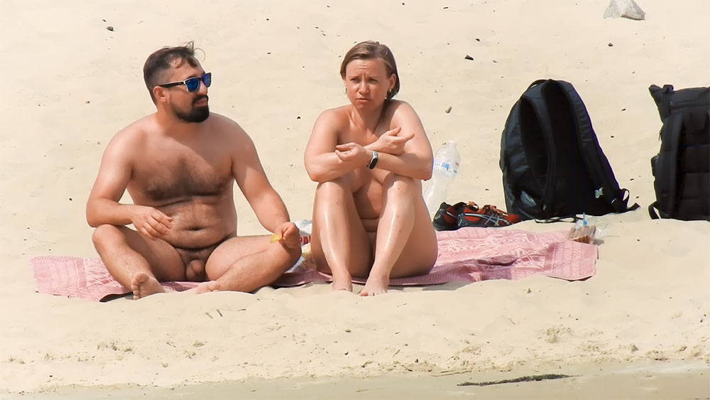 Nude Beach Couple Resting Together on a Sandy Shore