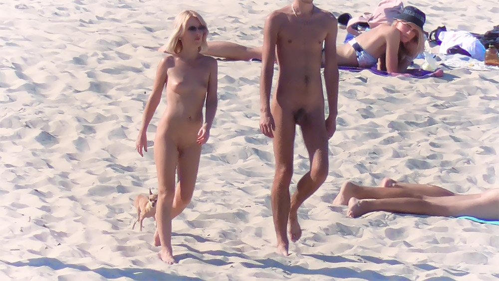 Vier naturisten samen op helder zand aan de oever