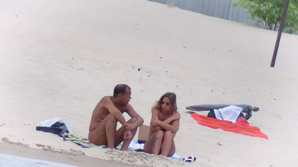 Nude Beach Couple Resting on Sand Near a Towel