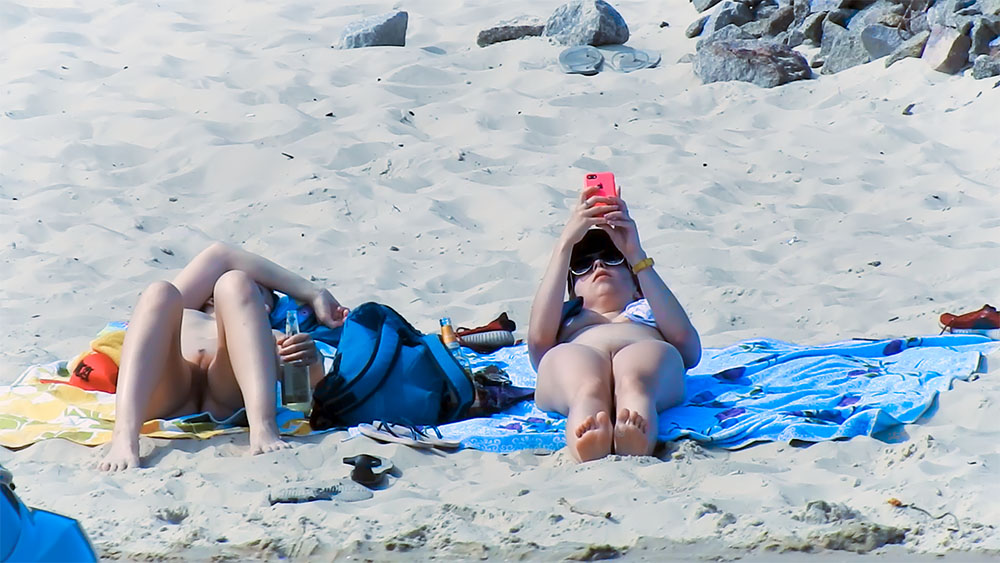 One Woman Topless on a Blue Patterned Beach Towel